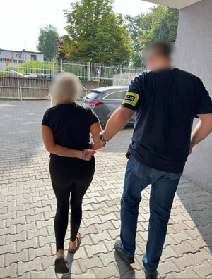 zatrzymana kobieta prowadzona przez nieumundurowanego policjanta