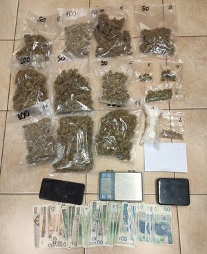 Narkotyki w woreczkach strunowych obok waga i banknoty