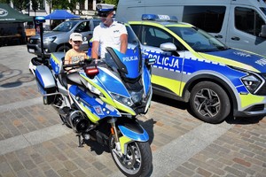 policjant ruchu drogowego oraz dziecko na policyjnym motocyklu