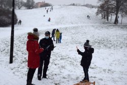 2 policjantka przekazuje dziecku i jego opiekunce zasady bezpieczeństwa na zaśnieżonym pagórku w parku
