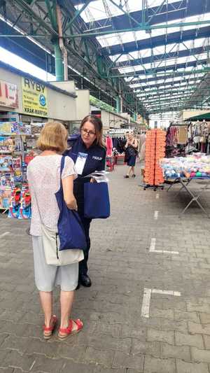 policjantka wręcza ulotki profilaktyczne seniorce