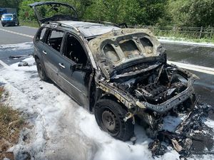 KPP Oświęcim. Pożar samochodu na obwodnicy Oświęcimia  (1) spalony pojazd na jezdni  w tle radiowóz