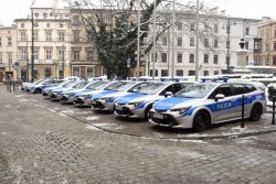 Nowe radiowozy zaparkowane na placu przed Urzędem Miasta Krakowa