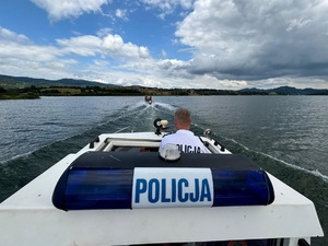policjanci płyną łodzią policyjną