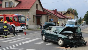 KPP Oświęcim. Kolizja Kęty zderzenie samochodów potrącenie pieszych 04.08 (4) uszkodzony samochód na jezdni w tle wóz strażacki i radiowóz