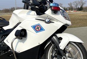 Policjant ruchu drogowego stoi przy motocyklu policyjnym