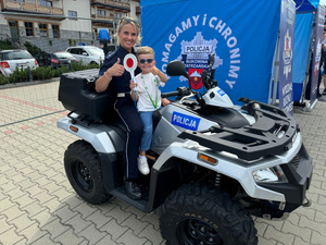 1 policjantka z dzieckiem na służbowym quadzie