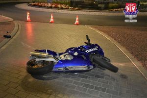 leżący na jezdni niebiesku motocykl, który porzucił uckekający przed policjantami mężczyzna