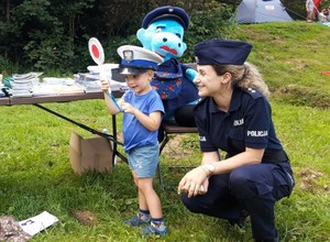 policjantka wraz z dzieckiem, które trzyma w ręku tarczę do zatrzymywania