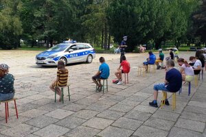 Bezpieczne Wakacje policjant omawia zasady bezpieczeństwa na półkolonii w Szkole Podstawowej Numer 11.