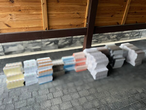 leżąca góra paczek papierosów na podłodze w pomieszczeniu.