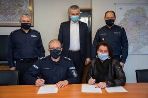 insp. Roman Kuster i  Magdalena Balawajder siedzą przy stole a za nimi stoją insp Robert Strzelecki, insp. Robert Górka i prof. Norbert G. Pikuła