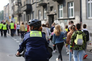 strażniczka miejska na rowerze zabezpiecza przejście dzieci