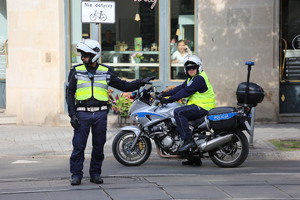 motocyklista policyjny i drugi policjant kierują ruchem