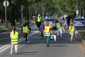 dzieci biegną zamkniętą przez policjantów ulicą 3 maja