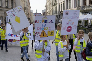 ręcznie wykonane transparenty niesione z dziećmi z hasłami np. bezpieczni na drodze