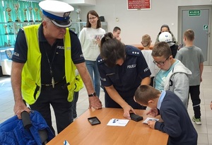 policjant i policjantka robia odciski palców dzieciom
