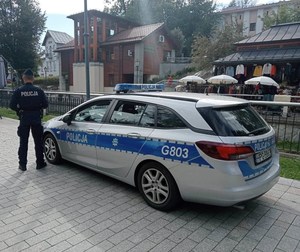 Radiowóz oznakowany  obok  umundurowany polijcant - zabezpieczenie prewencyjne forum Krynica