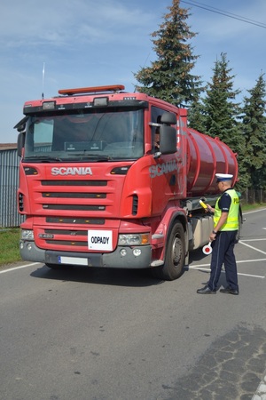 Policjant Ruchu Drogowego bada trzeźwość kierującemu pojazdem ciężarowym