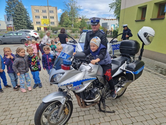 dzieci przy policjancie i motocyklu