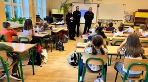 policjanci prowadzący zajęcia edukacyjne w szkole podstawowej