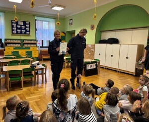 policjantki prowadzące zajęcia edukacyjne w przedszkolu