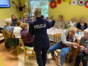 Umundurowana policjantka prowadzi prelekcję i rozdaje odblaski