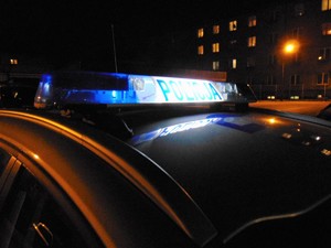 Radiowóz na tle bloków w nocy