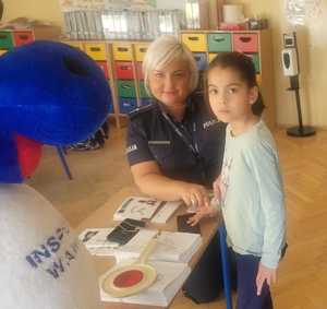 policjantka wykonuje odciski palców uczennicy