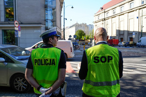 policjant i funknonariusz SOP w odblaskowych kamizelkach na skrzyżowaniu