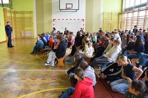 Policjant wygłasza prelekcję dla uczniów szkoły podstawowej