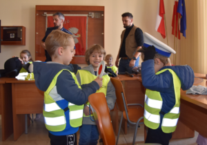 Uczniowie mierzący elementy policyjnego umundurowania