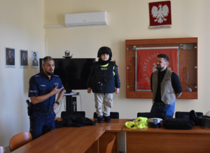 Policjanci i przedszkolak ubrany w elementy policyjnego umundurowania