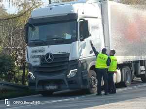 Umundurowani policjanci kontrolujący kierowcę samochodu ciężarowego