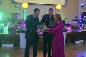 Policjanci odbierają statuetki od kobiety na scenie