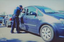 policjant zaglądający do pozostawionego w upale samochodu