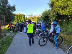 dzieci wraz nauczycieleam i policjantką sprawdzają stan i wyposażenie rowerów