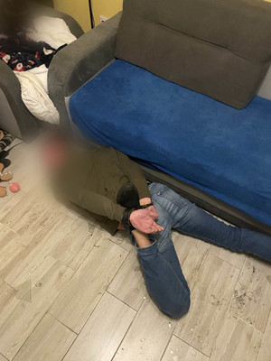 Mężczyzna leży na ziemi, ręce skute kajdankami z tyłu