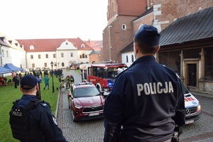 policjanci w trakcie ćwiczeń, w tle pojazdy strażackie i obserwatorzy ćwiczeń