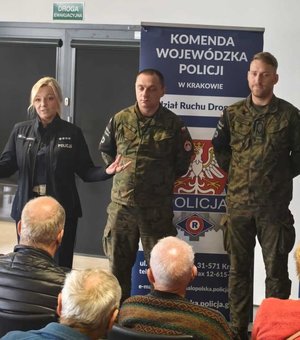 Policjantka przemawia do uczestników spotkania obok stoją żołnierze Żandarmerii Wojskowej