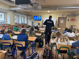 policjant w sali lekcyjnej podczas egzaminu uczniów na kartarę rowrową