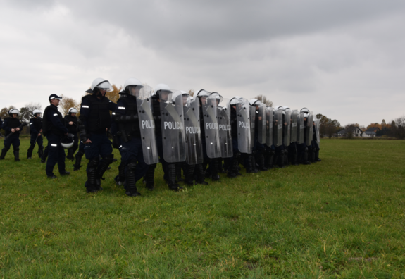 Umundurowani policjanci z tarczami podczas wykonywania ćwiczeń