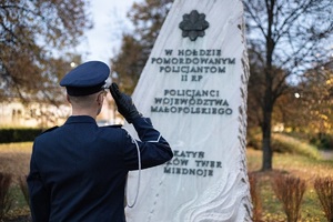 Policjant przed obeliskiem