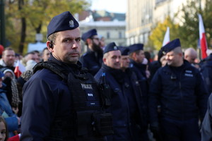 policjanci zabezpieczający uroczystość przed kończącą wydarzenie paradą służb