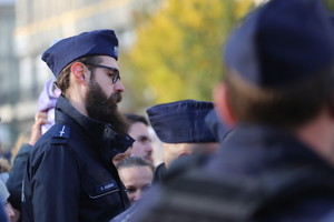policjant z brodą przed paradą służb