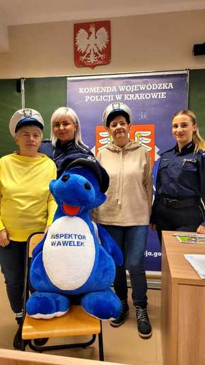 seniorki na pamiątkowym zdjęciu z inspektorem wawelkiem i policjantkami