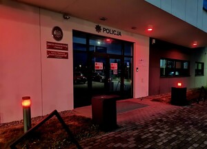 Wejście do budynku wadowickiej komendy podswietlone na czerwono.