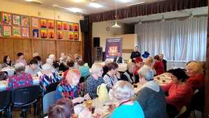 seniorzy siedzący przy stołach