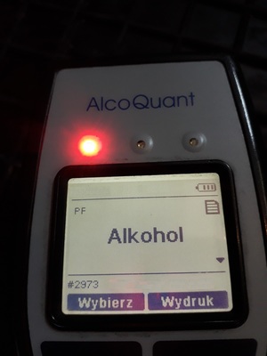 fragment elektronicznego urządzenia z widocznym kominukatem ALKOHOL na wyświetlaczu i zapaloną czerwoną lampką na obudowie