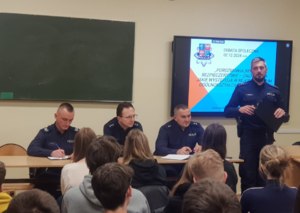 Bocheńscy policjanci oraz uczestnicy debaty. Na zdjęciu widoczna prezentacja z tytułem debaty